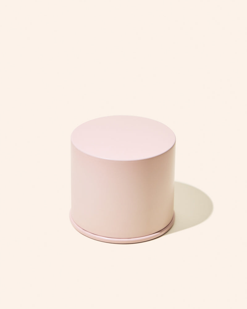 Pink cylindrical container on a light pink background