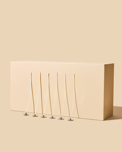 Beige box with five thin, metallic stakes on a beige background