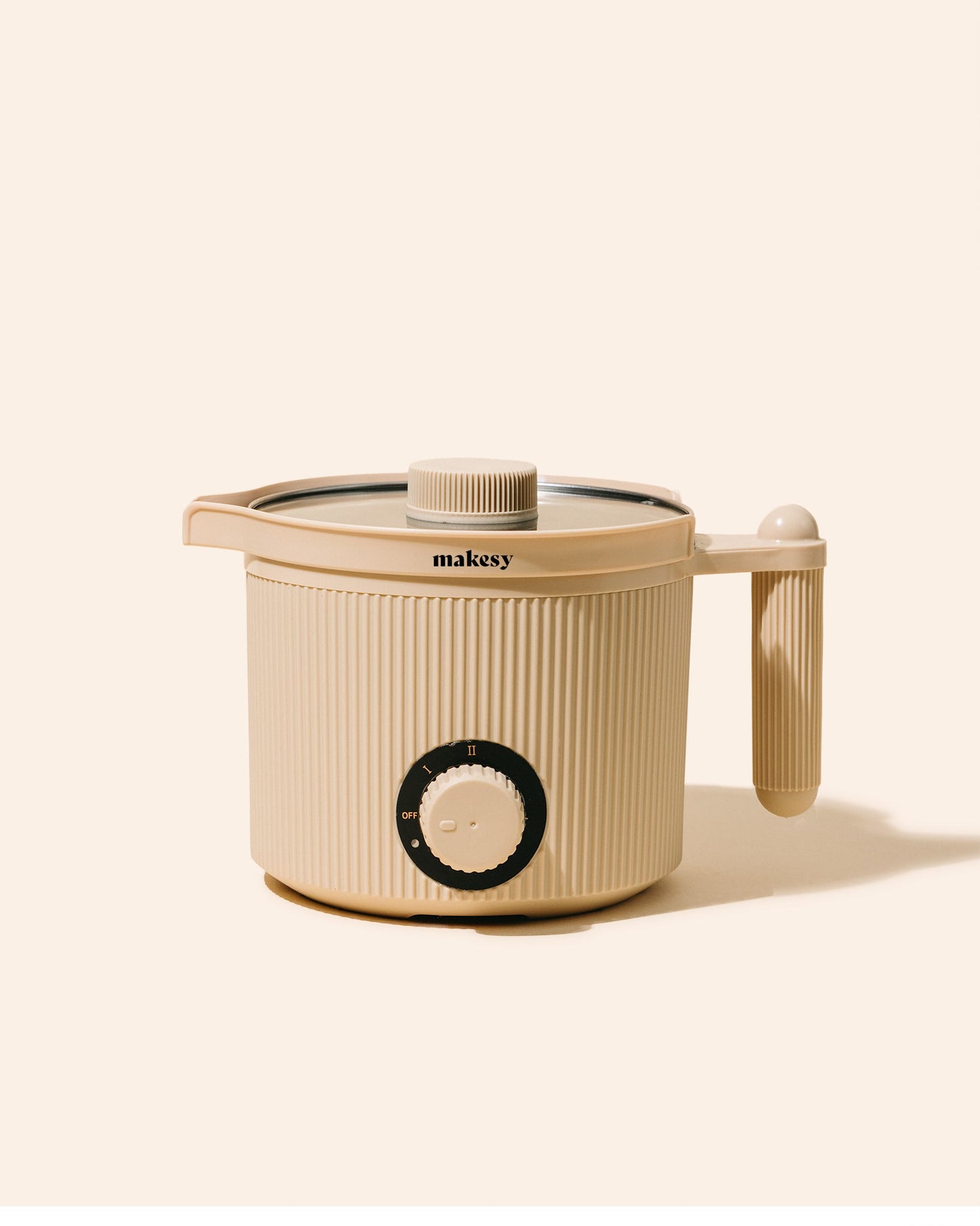 Beige kitchen appliance with lid and handle on a white background