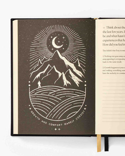 Open book with a mountain and moon illustration on a white background