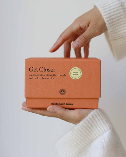 Person holding an orange box with text on a light background
