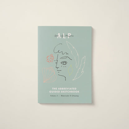 Light blue guided sketchbook with artistic design on a beige background