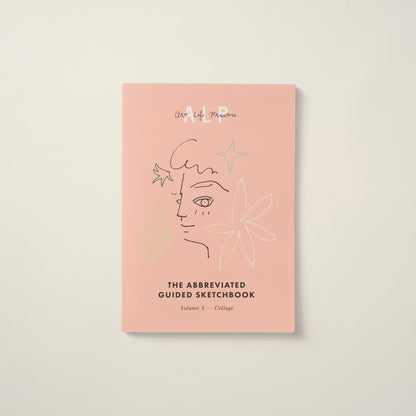 Pink book titled 'The Abbreviated Guided Sketchbook' with artistic line drawings on a light beige background