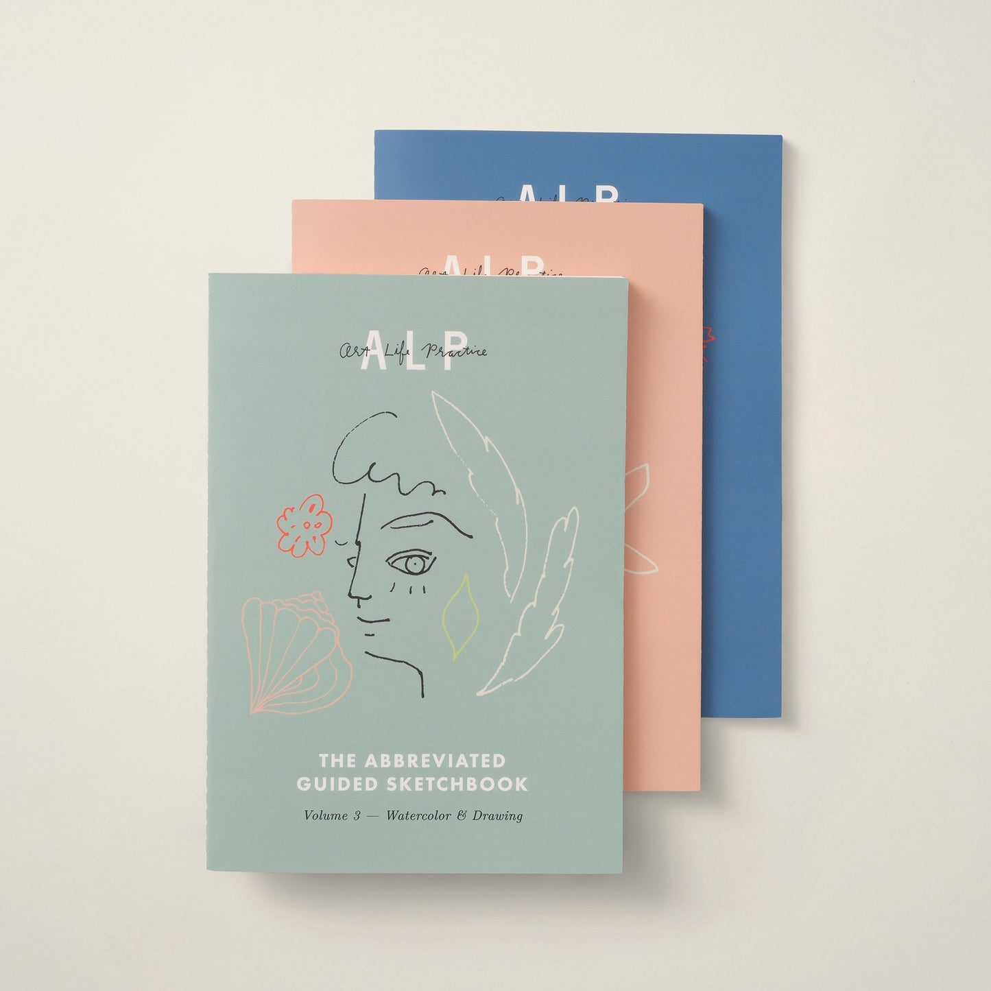 Three notebooks with artistic covers on a light beige background