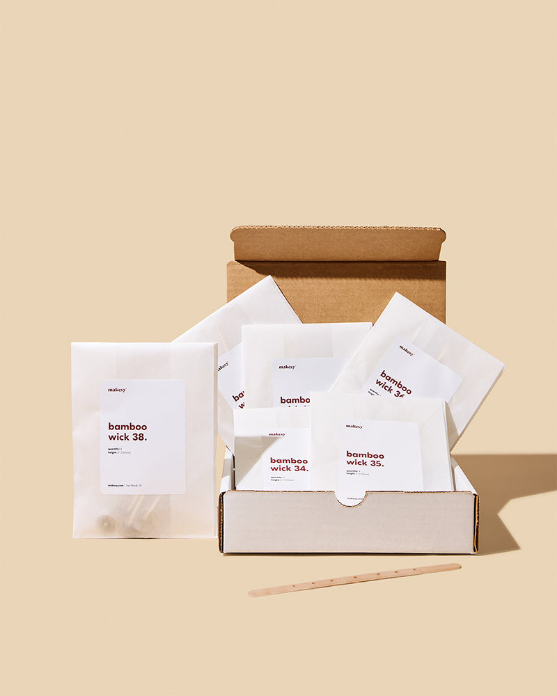Box of bamboo wick products with labels on a beige background