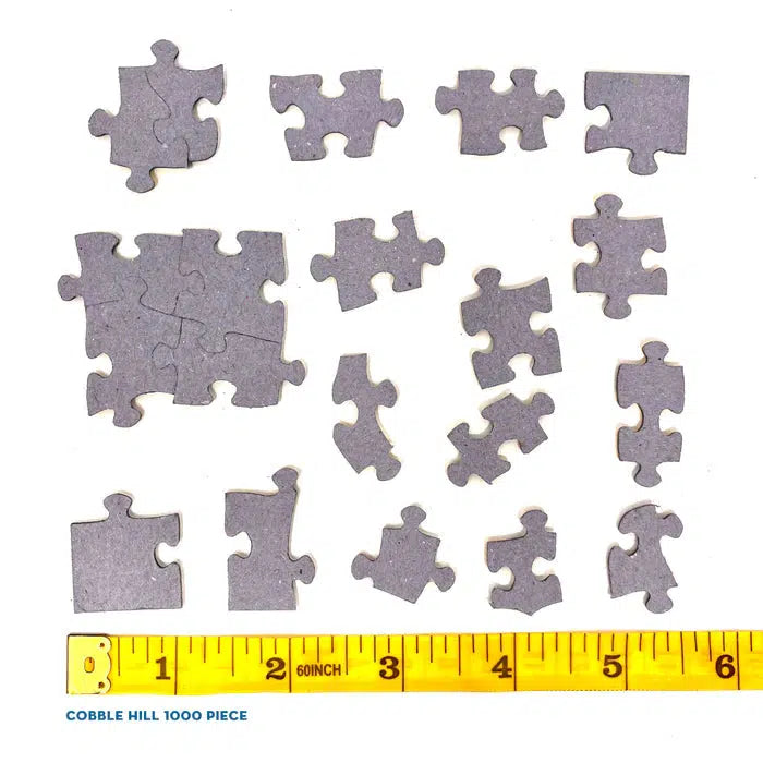 Jigsaw puzzle pieces with a measuring tape for scale on a white background