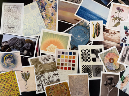 Collection of variously sized and shaped postcards with different designs.