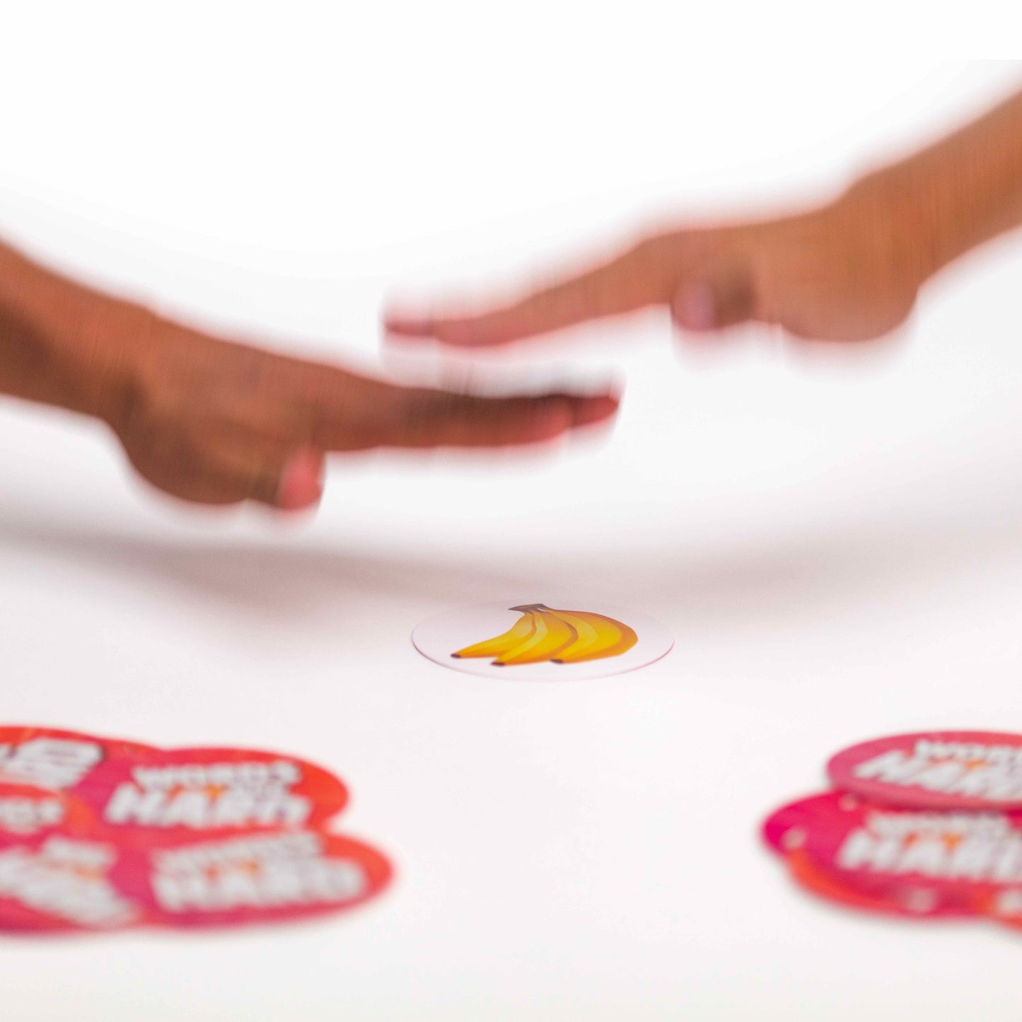Two hands reaching towards each other with a banana sticker on a white background
