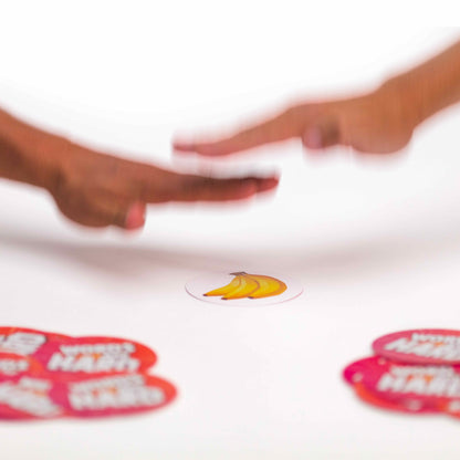Two hands reaching towards each other with a banana sticker on a white background