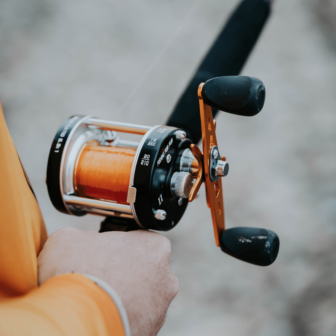 Fishing reel held by a person with a blurred background