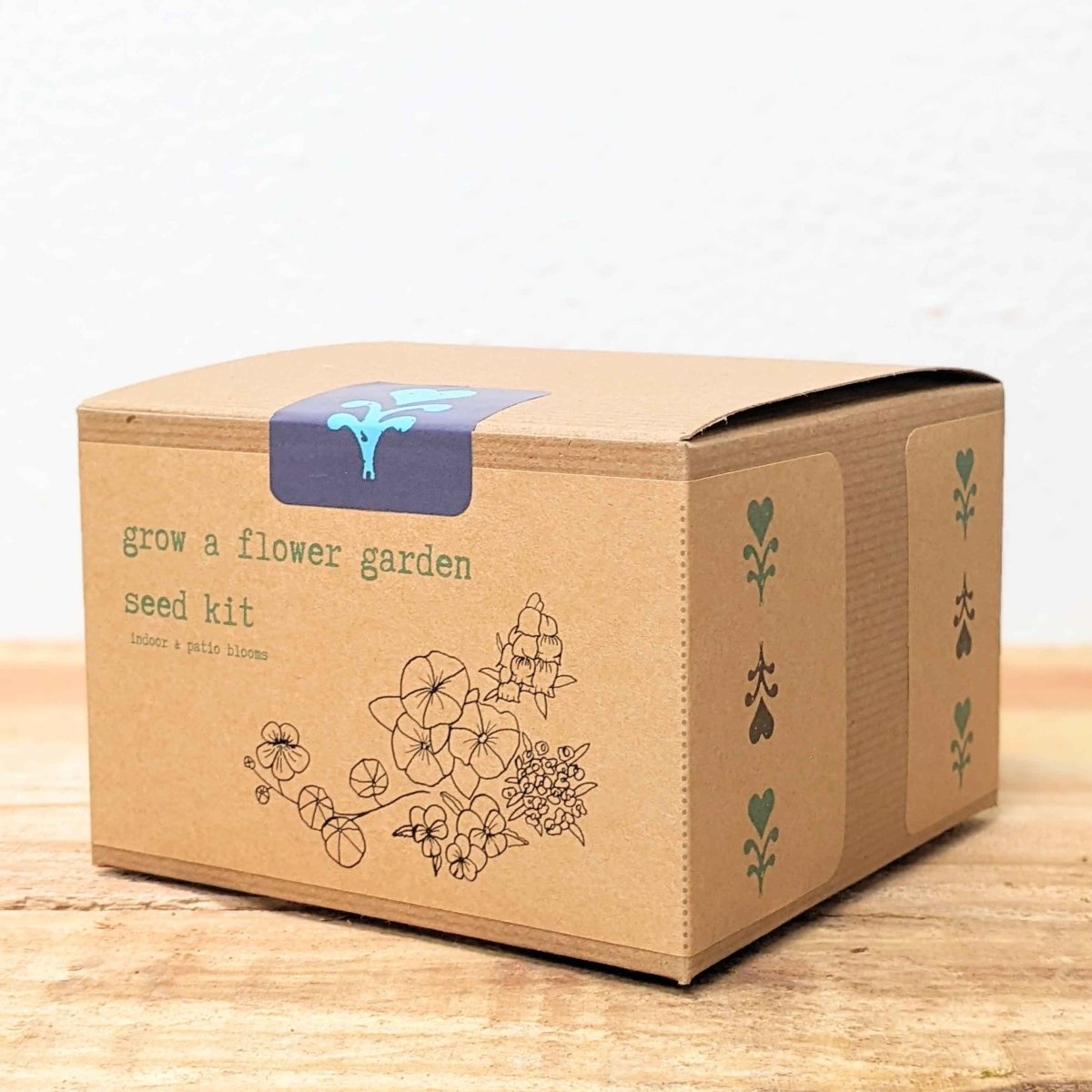 Cardboard box with 'grow a flower garden seed kit' text on a wooden surface