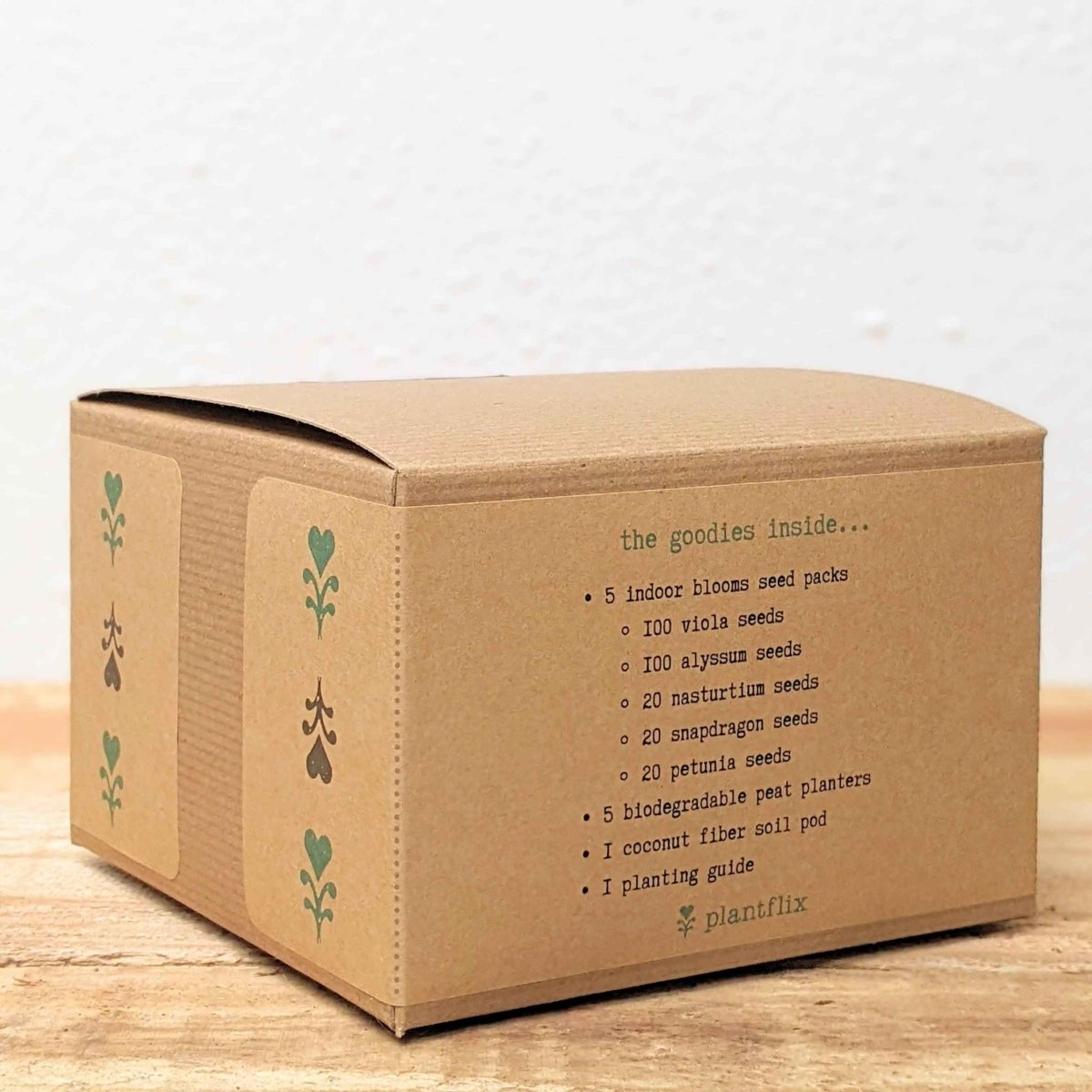 Cardboard box with plant-related text and illustrations on a wooden surface