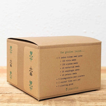 Cardboard box with plant-related text and illustrations on a wooden surface