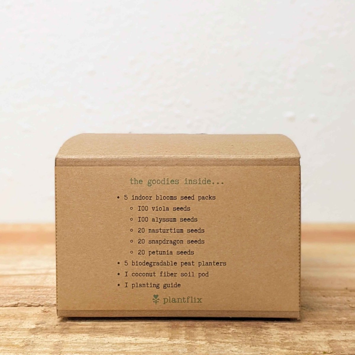 Brown cardboard box with seed packets on a wooden surface
