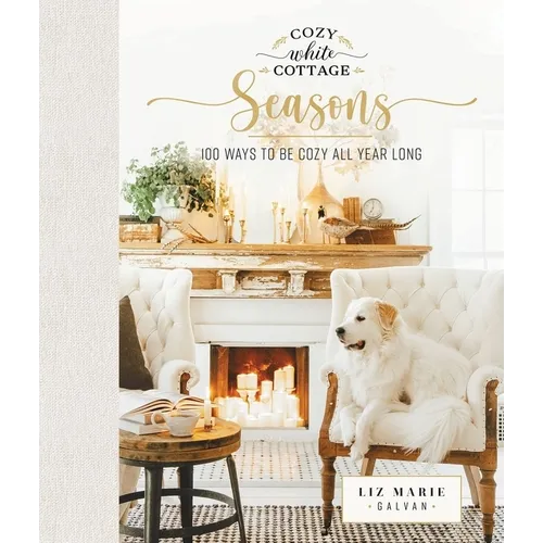 Book cover of 'Cozy White Cottage Seasons' with a fireplace and dog in a cozy living room.